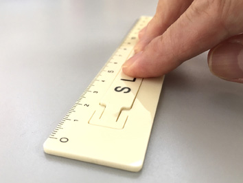 浮き上がった平らなスリット面を軽くワンプッシュするだけで定規を安定して固定できるので指先が疲れません。また、合わせた位置も正確に固定できます。ずれない定規,滑らない定規,固定も移動も自在にできる定規,レトロ定規,non-slip ruler
